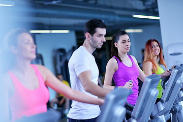 Image showing Group of people running on treadmills