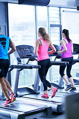 Image showing Group of people running on treadmills