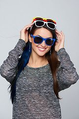 Image showing Smiling woman wearing many colourful sunglasses