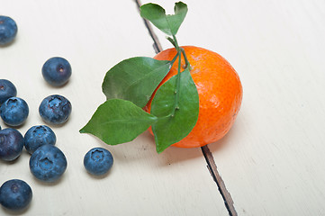 Image showing tangerine and blueberry on white table