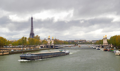 Image showing Eiffel Tower on the bank of river Seine with ship spring cloudy day