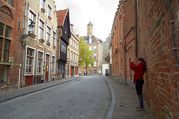 Image showing tourist woman taking photo of city Bruges on mobile gadget, Belgium