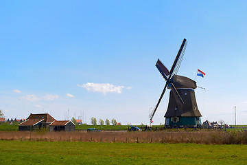 Image showing Sunny Dutch landscape in springtime with green grass and an historic mill.