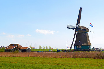 Image showing Sunny Dutch landscape in springtime with green grass and an historic mill.