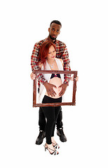 Image showing Pregnant couple holding picture frame.