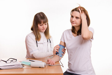 Image showing Therapist puts the cuff on the arm of the patient tonometer