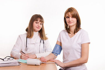 Image showing The therapist measures the pressure of a young girl in the office