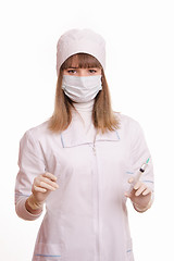 Image showing Health worker in a white robe, mask, gloves with a syringe and vial in hands