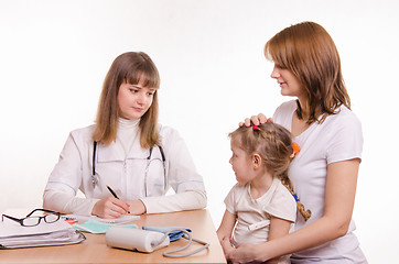 Image showing Pediatrician listens to the complaints of the little girl and her mother