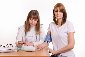 Image showing Physician writes tonometer readings in the patient card