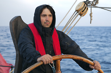 Image showing Young sailor steering tall ship