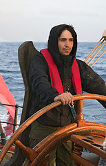 Image showing Young sailor steering tall ship