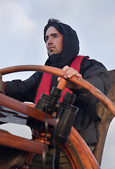 Image showing Young sailor steering tall ship