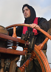 Image showing Young sailor steering tall ship