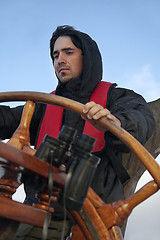 Image showing Young sailor steering tall ship