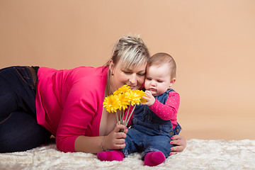 Image showing infant baby with his mom and yellow flowers