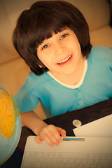 Image showing smiling boy doing homework on computer