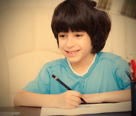 Image showing smiling child doing homework with computer