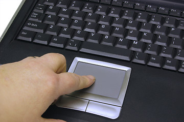 Image showing finger on the mouse pad of a  laptop keyboard