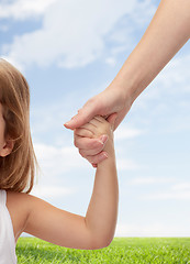 Image showing close up of woman and little girl holding hands