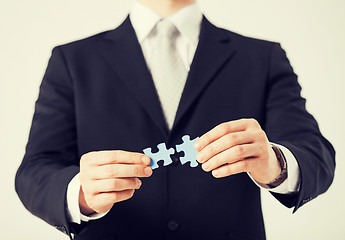 Image showing man trying to connect puzzle pieces