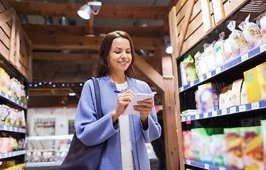 Image showing happy woman with notepad in market