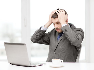 Image showing busy businessman with laptop and coffee