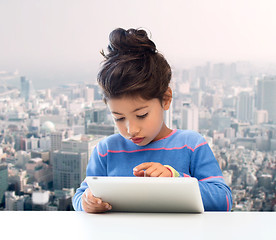 Image showing little girl with tablet pc over city background