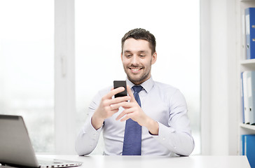 Image showing businessman with laptop and smartphone at office