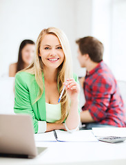 Image showing smiling student girl with laptop at school