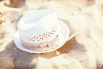 Image showing white straw hat lying in the sand on the beach