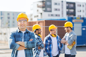 Image showing group of smiling builders in hardhats outdoors