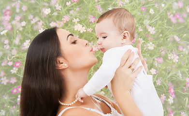 Image showing happy mother kissing and holding baby