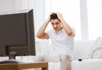 Image showing disappointed man watching tv at home