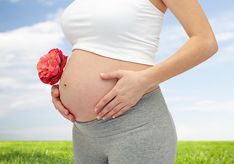 Image showing close up of pregnant woman touching her bare tummy