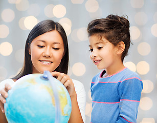 Image showing happy mother and daughter with globe