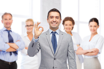 Image showing happy businessman in suit showing ok hand sign