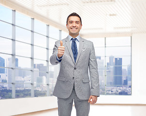 Image showing happy businessman in suit showing thumbs up