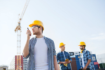 Image showing group of builders in hardhats with radio