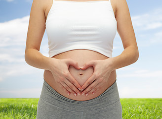 Image showing close up of pregnant woman touching her bare tummy