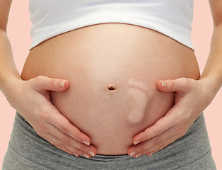 Image showing close up of pregnant woman touching her bare tummy