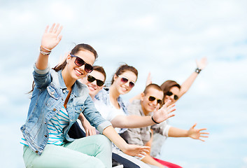 Image showing group of teenagers waving hands