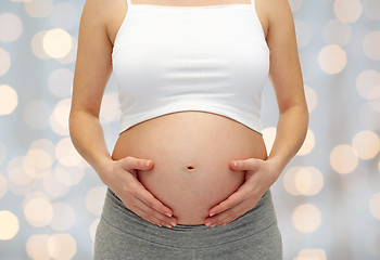 Image showing close up of pregnant woman touching her bare tummy