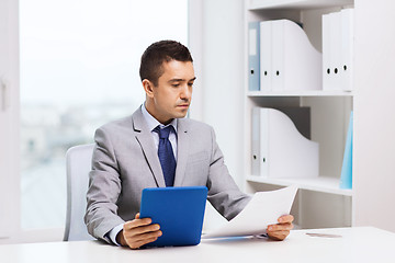 Image showing businessman with tablet pc and papers in office