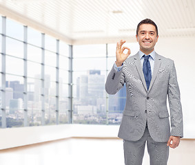 Image showing happy businessman in suit showing ok hand sign