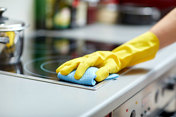 Image showing close up of woman cleaning cooker at home kitchen