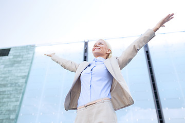 Image showing young smiling businesswoman over office building