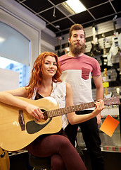 Image showing couple of musicians with guitar at music store