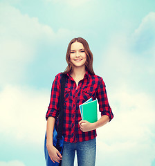 Image showing smiling female student with bag and notebooks