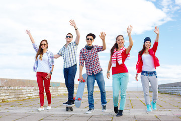 Image showing group of smiling teenagers waving hands